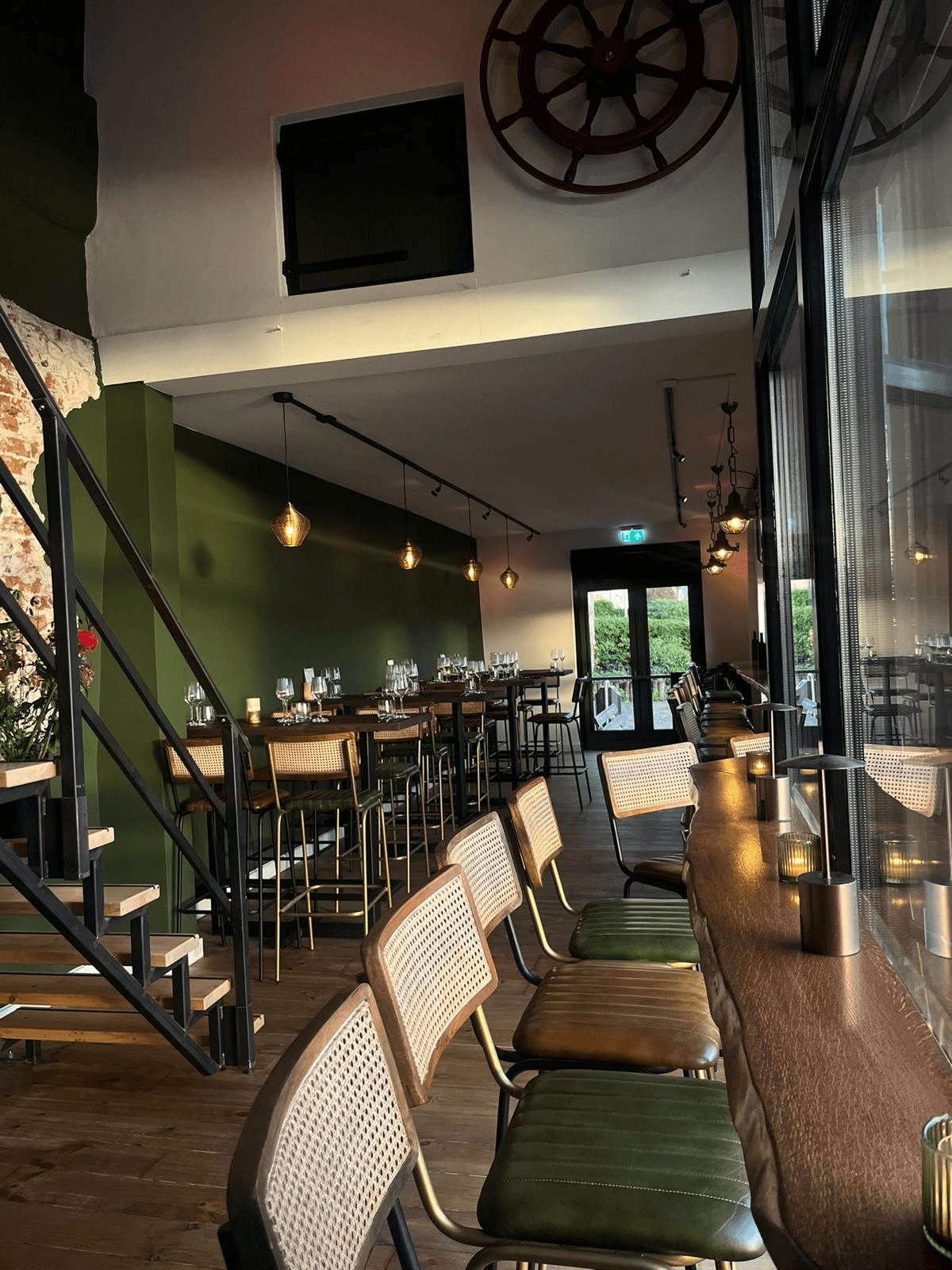 Restaurantinterieur van R.I.O. met groene wanden en zitplaatsen langs het raam